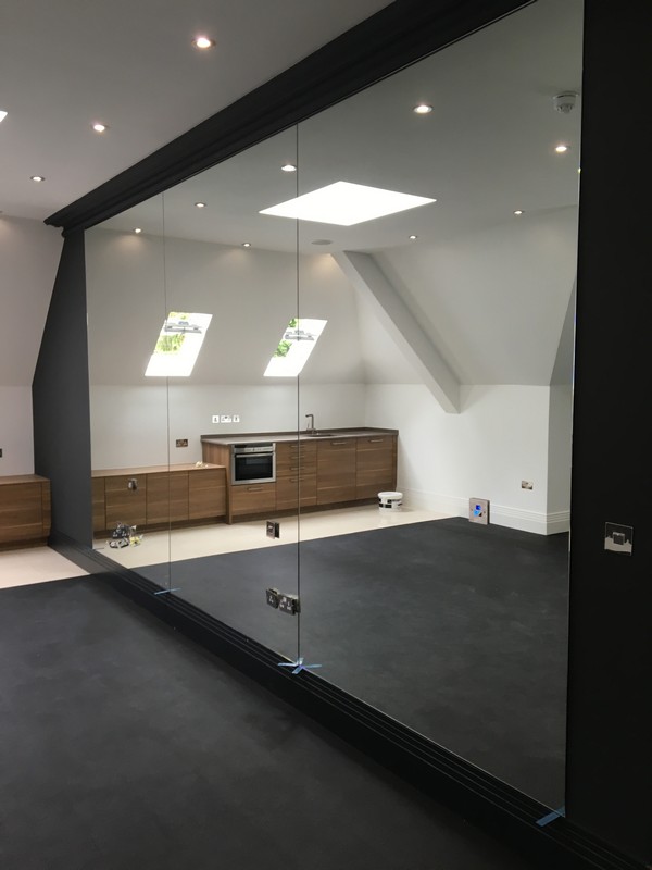 Frameless glass partition in loft conversion by Coulsdon glaziers