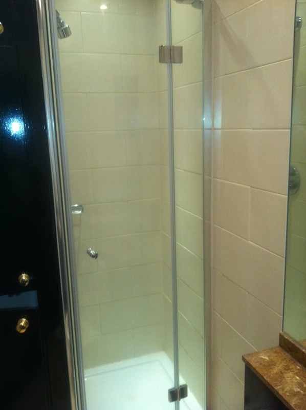 Frameless glass shower enclosure with chrome fittings in Coulsdon